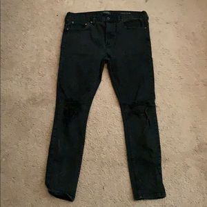 Black ripped stacked skinny jeans.